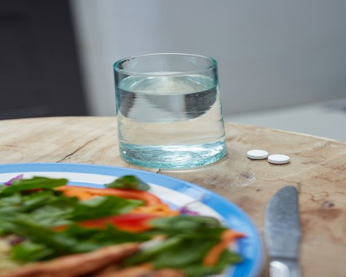 A glass of clean mineral water placed alongside a simple fresh homemade meal